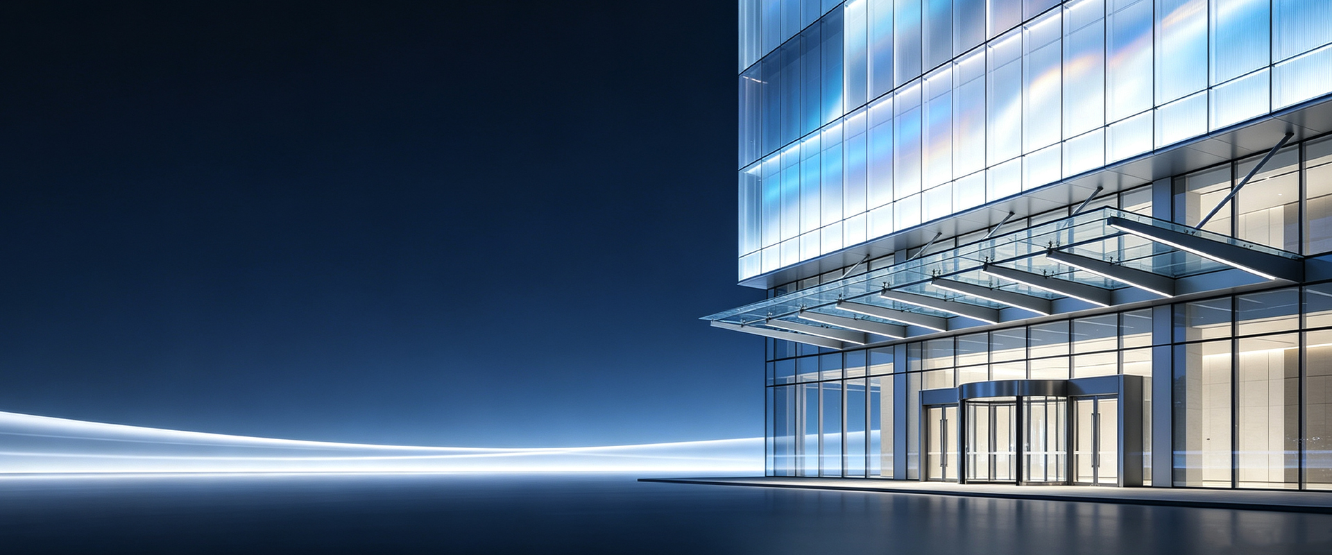 Illuminated glazed entrance canopy on a commercial building facade at night
